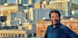 OPCD Further Trims Corridor Upzones in Newly Unveiled Seattle Zoning Maps Rico is a Black man with braids and a button up shirt posing in front of the Seattle skyline