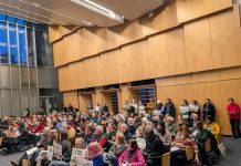 Turn Out for Housing at Seattle Hearings This Week The Seattle council chambers are filled to the brim. People hold signs to promote their views.