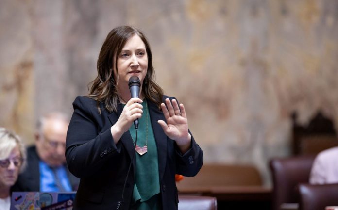 state-sen.-noel-frame-scaled-1 1600 Frame holds a microphone on the floor of senate chambers.
