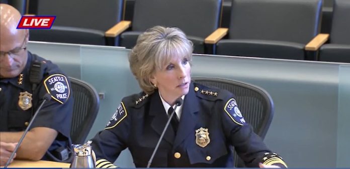 Rahr wears her dark blue police uniform with stars and shields on her shoulders.