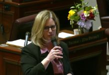 Washington Senate OKs Rent Stabilization Bill After Gutting It Cleveland hold the microphone on the floor and has blond hair and glasses. On the Annette Cleveland desk behind her is a bouquet of flowers.