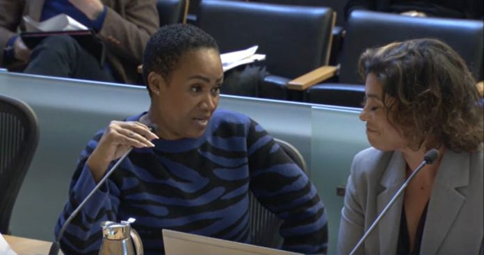 Deputy Mayor Washington and Auditor team - Seattle Channel Washington is a black woman with short hair. She holds the microphone and looks to her left toward Natalie Walton-Anderson and the auditor as she delivers her rebuttal.