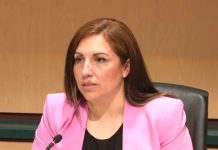 Trump Shreds Social Safety Net, Creating Perfect Storm for Homelessness Mosqueda sits at the dais. She is a Latina wearing a hot pink blazer.