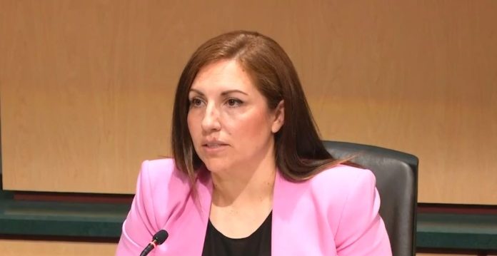 Teresa Mosqueda at King County Council Chambers via KCTV Mosqueda sits at the dais. She is a Latina wearing a hot pink blazer.