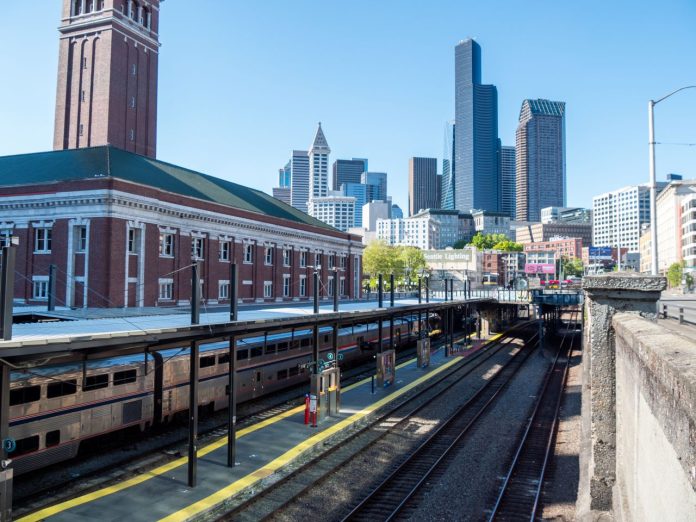 King Street Station with the downtown Seattle skyline in the background on a clear sunny day.