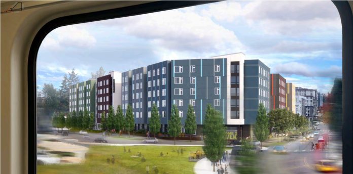 Bellwether Prisma Apartments view from 2 Line train A rendering shows a light rail window with a view of a large blue six story building with a big green lawn in front.