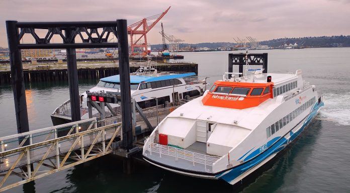 A Kitsap Transit fast ferry sits at the dock at Pier 50 with a King County Water Taxi