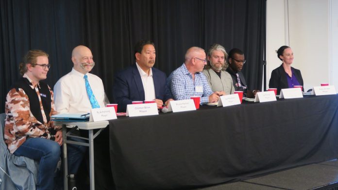 Seattle Mayor Forum 2025 PhotoCreditClaraCantor.16 The candidates sit at table with name tags in front.