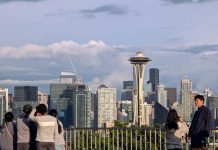 Seattle’s No-Cost Climate Pollution Cut A group of young people stand by the railing at Kerry Point with the Space Needle and downtown skyscrapers looming in the distance.