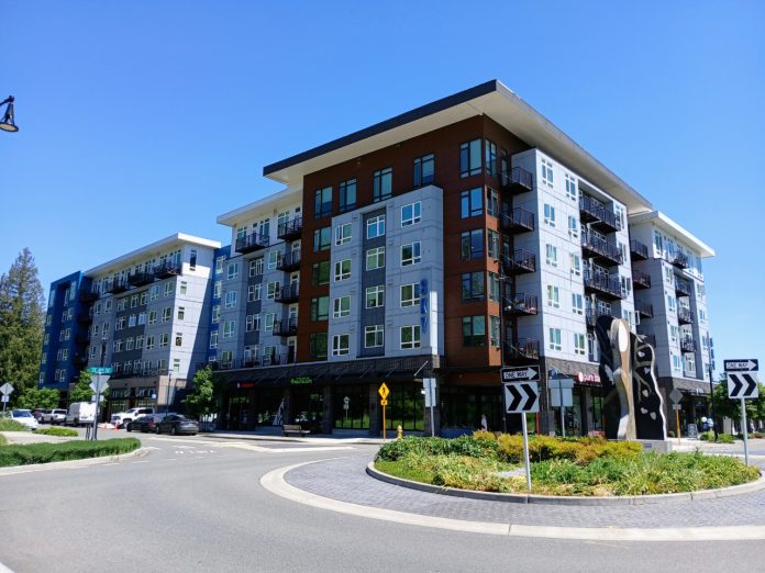 A six story apartment building in Sammamish next to a roundabout
