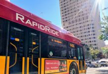 King County Advances K Line Designs for Eastside’s Next RapidRide A bright red RapidRide bus with the sun glinting in the sky