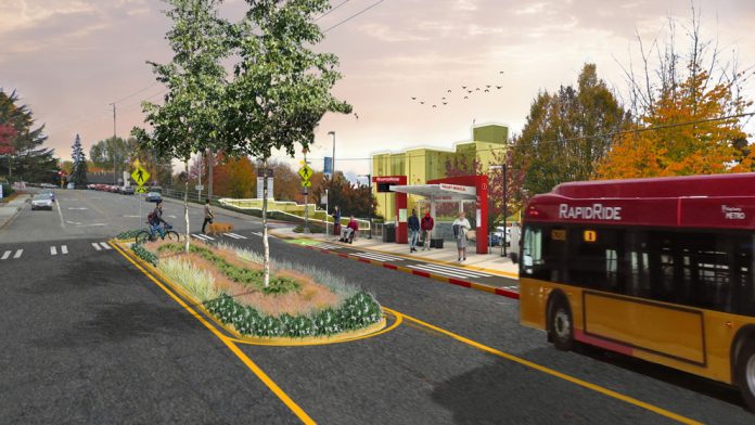 i_line_rendering_talbot_and_carr A rendering of a RapidRide bus arriving at a newly rebuilt bus stop with bus shelter and RapidRide pylon, with a median in the street adding trees and pedestrian safety. Riders wait under the shelter and two people use the cross walk, one walking a bike.