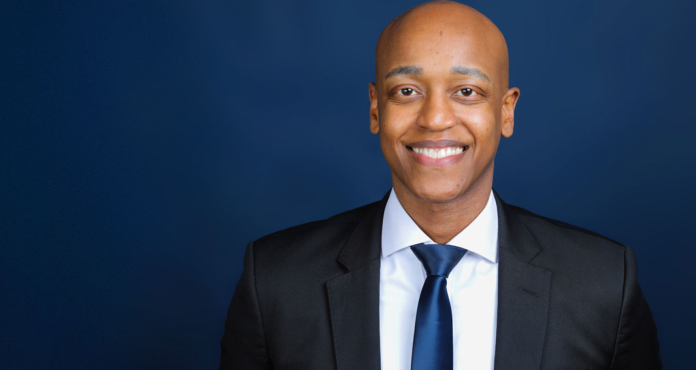 image Girmay Zahilay, a Black millennial man wearing a suit, standing in front of a blue background