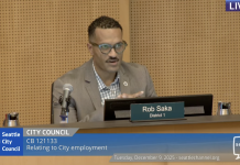 Seattle Approves Controversial Police Guild Contract, Three Councilmembers Dissent Councilmember Rob Saka sits on the council dais in a tan sportscoat.